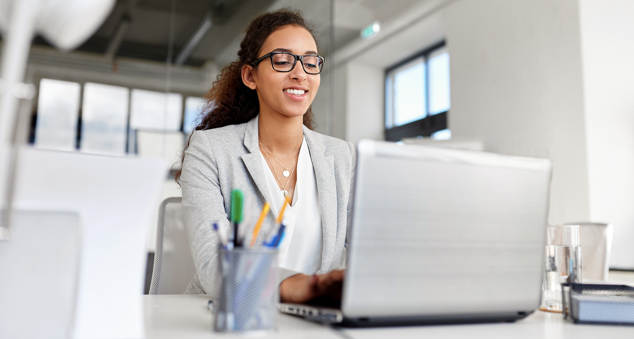 personne portant des lunettes et utilisant un ordinateur portable au bureau